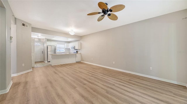 unfurnished living room with ceiling fan and light hardwood / wood-style flooring