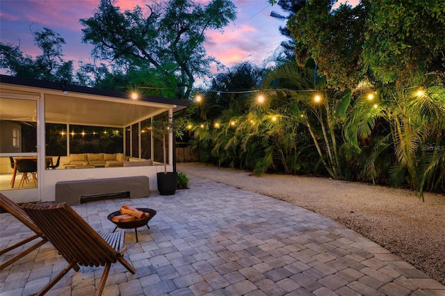 patio terrace at dusk featuring an outdoor living space with a fire pit