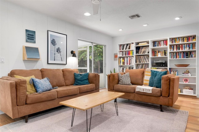 living room with ceiling fan, hardwood / wood-style floors, and a textured ceiling