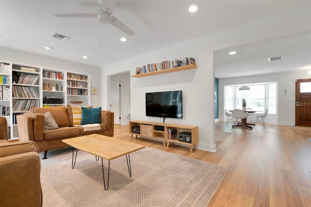 living room with ceiling fan and light wood-type flooring