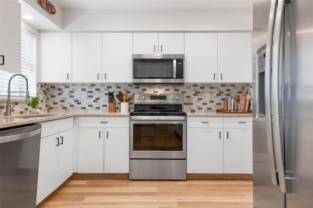 kitchen featuring backsplash, sink, white cabinetry, and stainless steel appliances