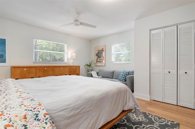 bedroom with ceiling fan, light hardwood / wood-style flooring, and a closet