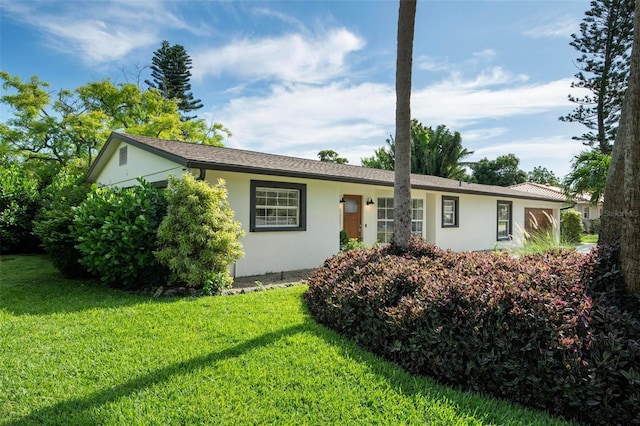 single story home featuring a front lawn