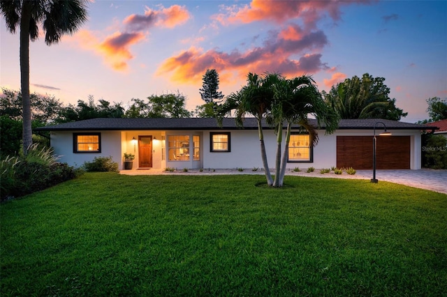 single story home featuring a yard and a garage