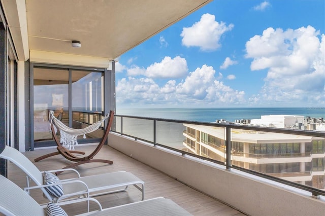 balcony featuring a water view and a beach view