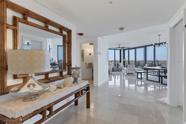 corridor with light tile patterned floors, an inviting chandelier, and expansive windows