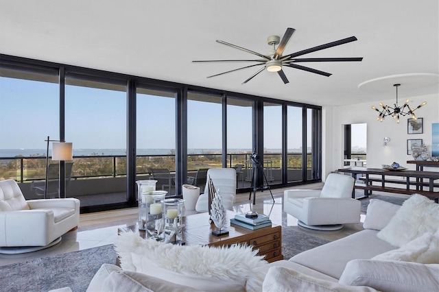 living room with ceiling fan with notable chandelier and floor to ceiling windows