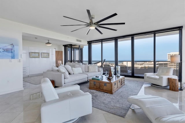 tiled living room with ceiling fan and a wall of windows