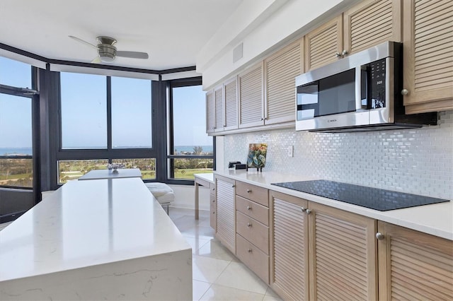 kitchen with decorative backsplash, light tile patterned flooring, black electric cooktop, and ceiling fan