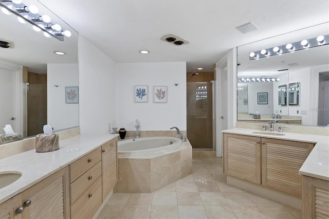 bathroom featuring tile patterned floors, vanity, and shower with separate bathtub