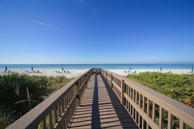 surrounding community with a water view and a beach view