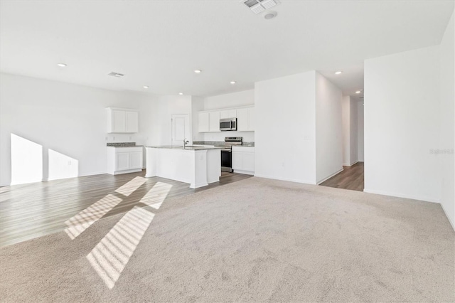 unfurnished living room featuring light colored carpet