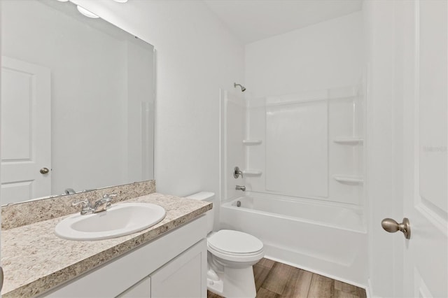 full bathroom featuring hardwood / wood-style floors, vanity, toilet, and shower / washtub combination