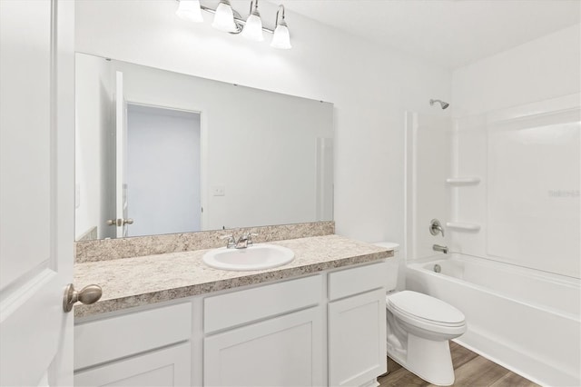 full bathroom with hardwood / wood-style flooring, vanity,  shower combination, and toilet