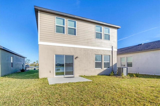 back of property with cooling unit, a patio area, and a yard