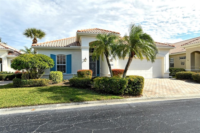 mediterranean / spanish home with a front yard and a garage