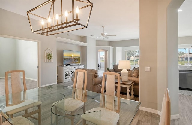 dining space featuring hardwood / wood-style floors and ceiling fan with notable chandelier