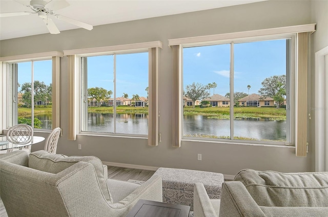 sunroom / solarium featuring a water view, ceiling fan, and a healthy amount of sunlight