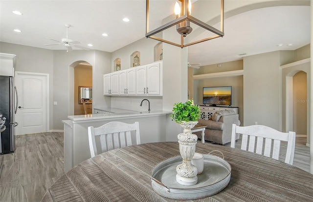 dining space featuring ceiling fan, sink, and light hardwood / wood-style flooring