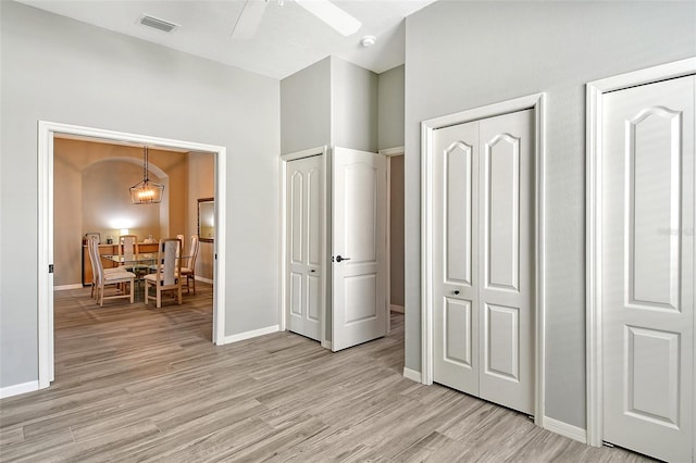 bedroom featuring two closets, ceiling fan, and light hardwood / wood-style floors