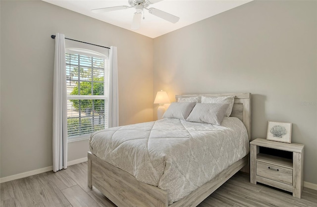 bedroom with multiple windows, ceiling fan, and light wood-type flooring