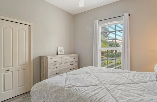 bedroom featuring light wood-type flooring, a closet, and ceiling fan