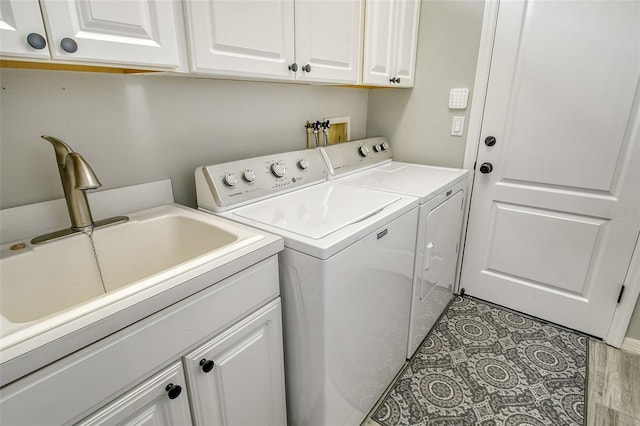 laundry room featuring cabinets, washer and clothes dryer, and sink