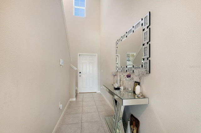 doorway to outside with light tile patterned floors and a high ceiling