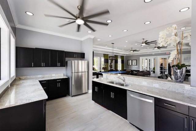 kitchen featuring light stone countertops, stainless steel appliances, crown molding, sink, and billiards