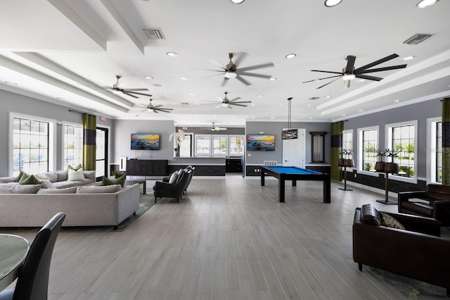 rec room featuring light hardwood / wood-style floors, ornamental molding, pool table, and a tray ceiling