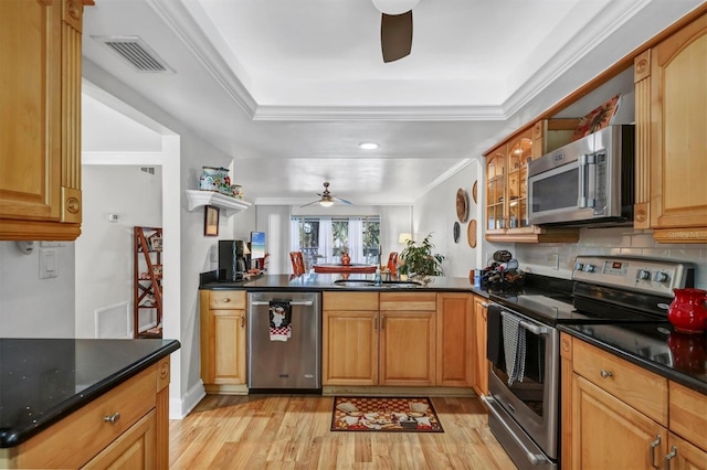 kitchen featuring sink, kitchen peninsula, crown molding, appliances with stainless steel finishes, and light wood-type flooring