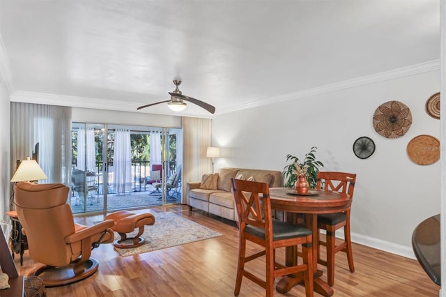 living room with crown molding, ceiling fan, and light hardwood / wood-style floors