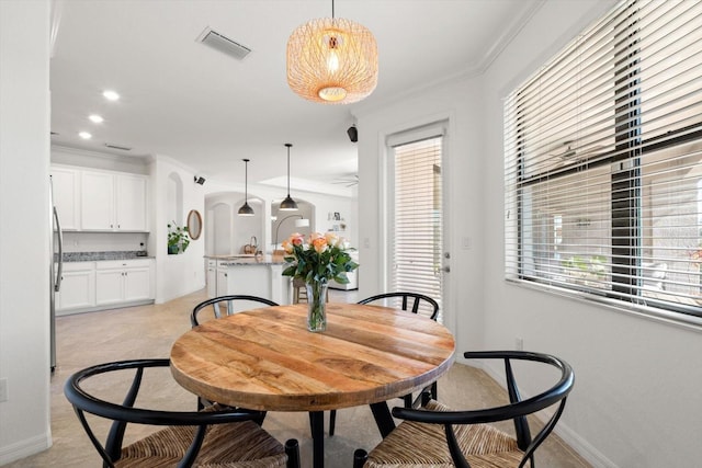 dining room with plenty of natural light and crown molding