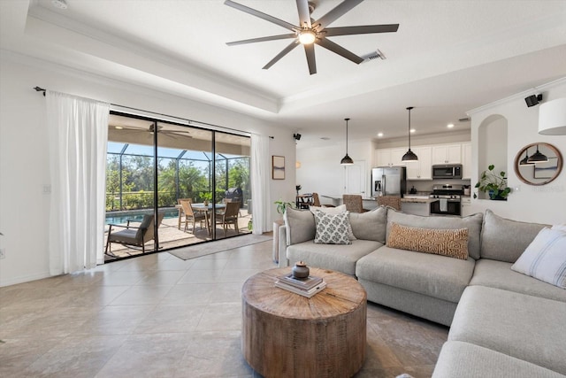 living room with a raised ceiling and ornamental molding