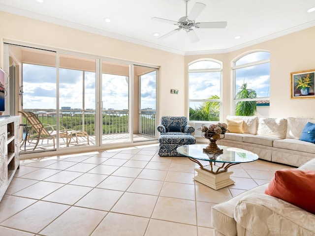 living room featuring crown molding, light tile patterned floors, and ceiling fan