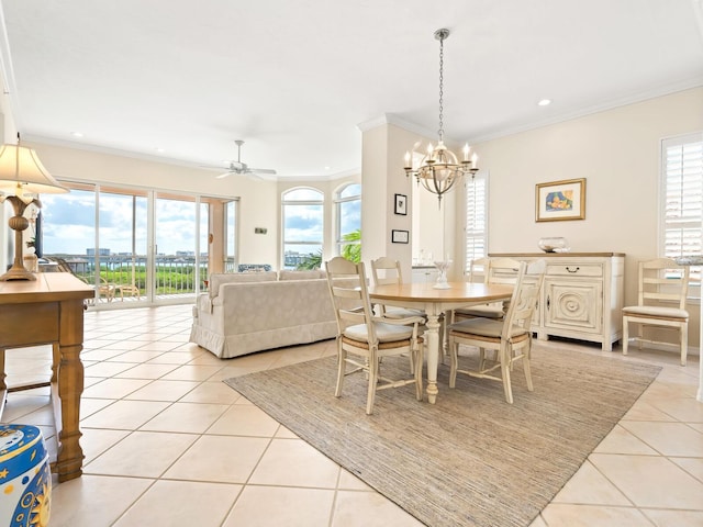 tiled dining area with ceiling fan with notable chandelier and crown molding