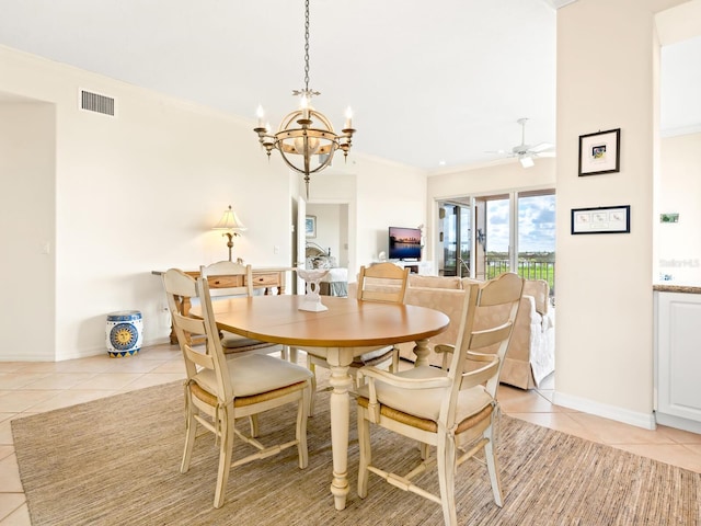 tiled dining area with ceiling fan with notable chandelier and crown molding