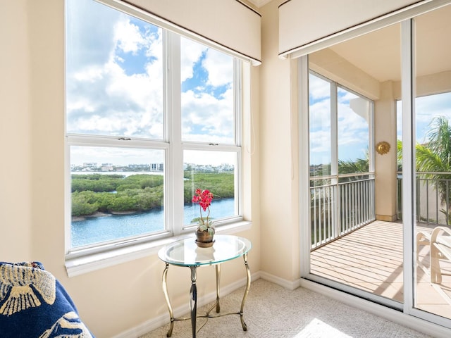 sunroom / solarium with a water view and a wealth of natural light