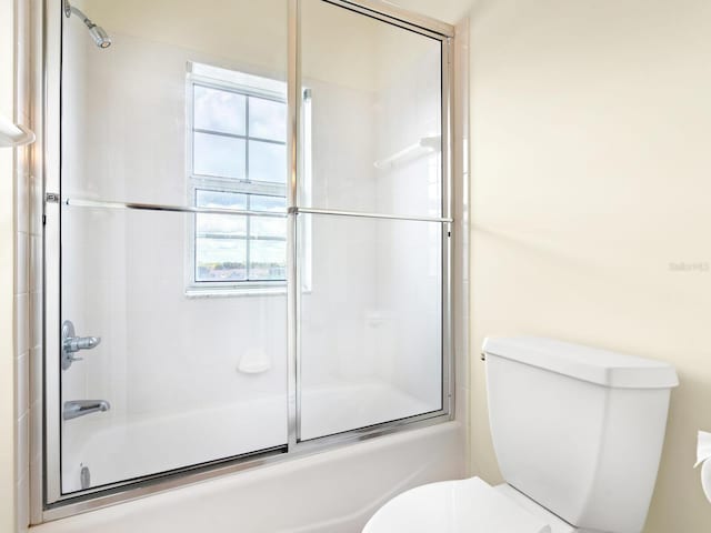 bathroom with toilet and enclosed tub / shower combo