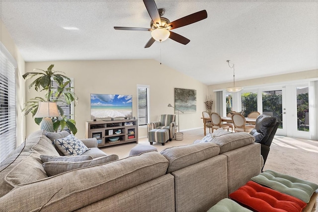 living room with a textured ceiling, carpet floors, vaulted ceiling, and ceiling fan