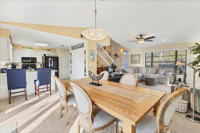 dining area with light carpet, vaulted ceiling, ceiling fan, and sink