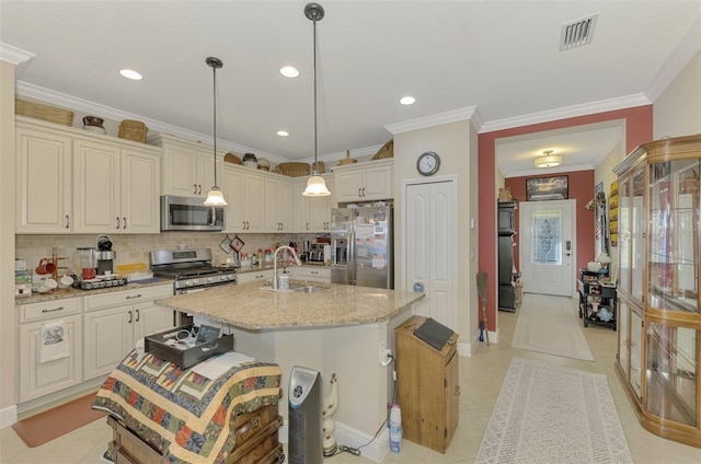 kitchen with pendant lighting, a center island with sink, decorative backsplash, appliances with stainless steel finishes, and light stone counters