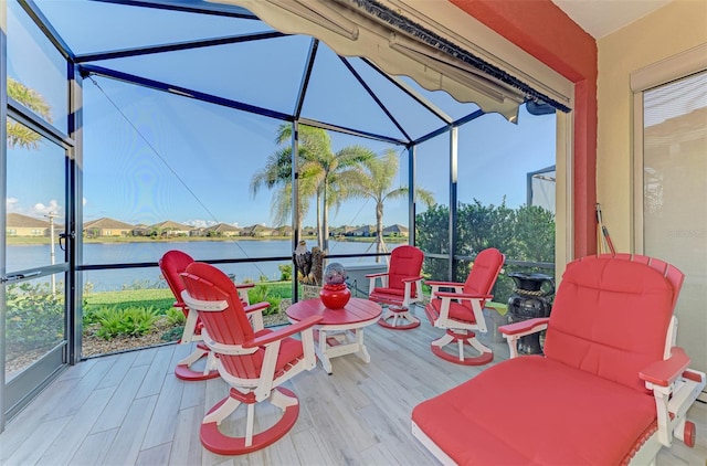 wooden deck with glass enclosure and a water view