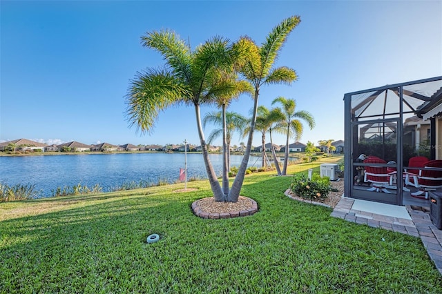 view of yard featuring a lanai and a water view