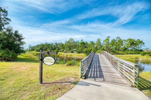 view of property's community featuring a yard and a water view