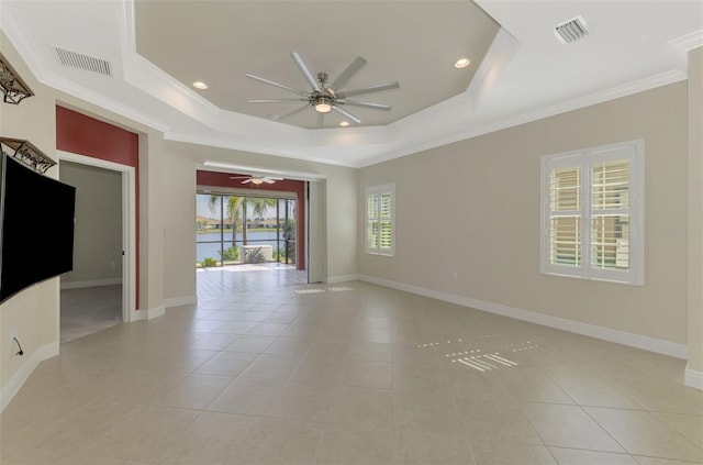 empty room featuring a raised ceiling, visible vents, and crown molding