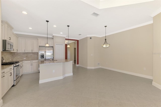 kitchen featuring stainless steel appliances, pendant lighting, light stone counters, and an island with sink