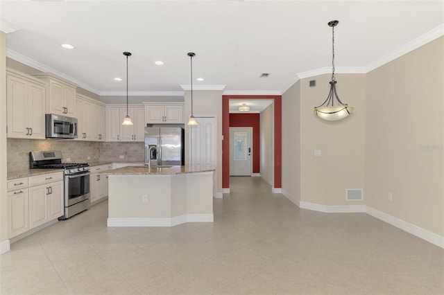 kitchen featuring an island with sink, decorative light fixtures, light stone countertops, stainless steel appliances, and backsplash