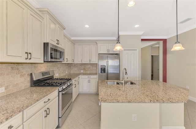 kitchen featuring hanging light fixtures, a kitchen island with sink, appliances with stainless steel finishes, and a sink