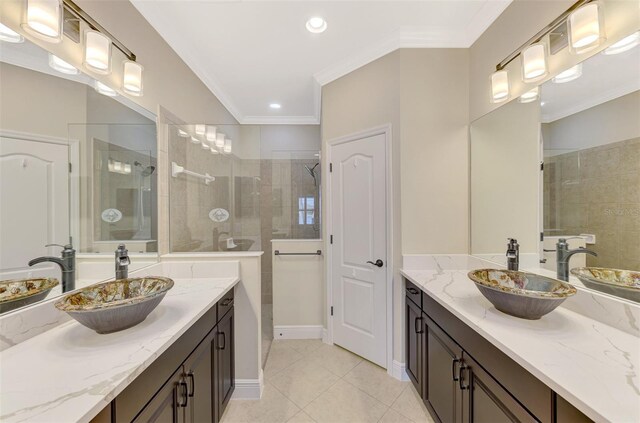 bathroom with ornamental molding, two vanities, a sink, and walk in shower